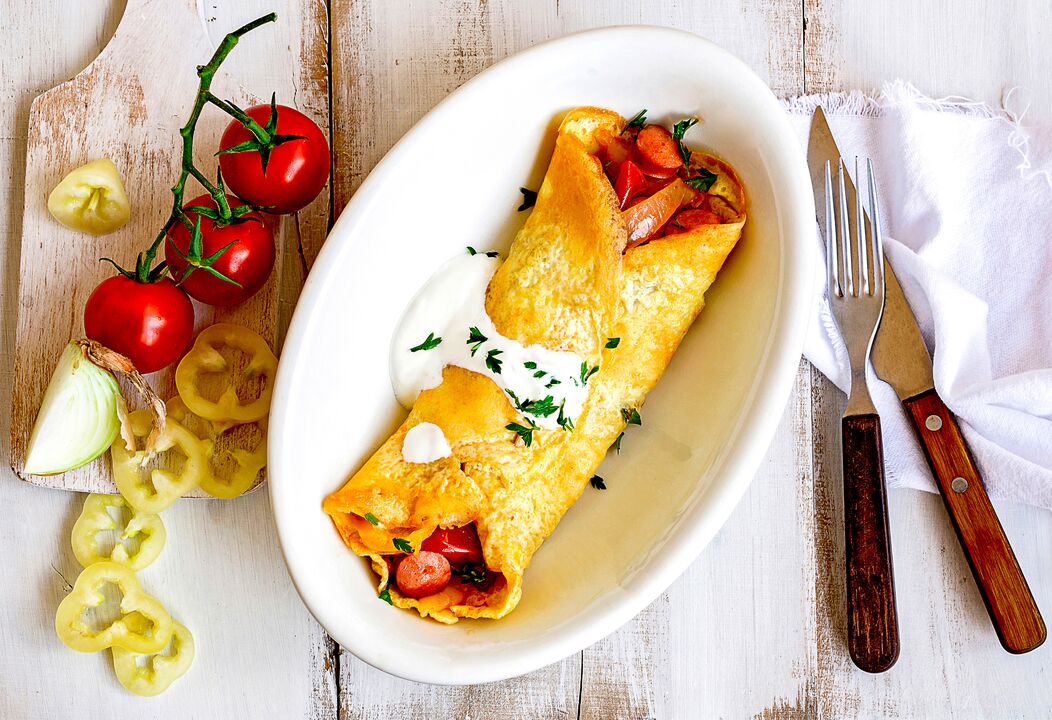 Reggelire a keto diétán fogyók egy omlettet sajttal, zöldségekkel és sonkával